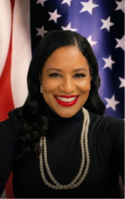 Professional woman smiling in front of American flags.